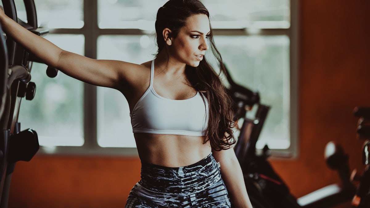 a woman in a sports bra top and leggings in a gym